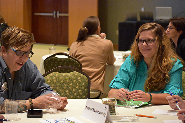 Amanda Nadel, who serves as the Dorchester Prosperity Center Specialist at TUW, listens as Toni Flowers reads statements aloud. Participants put one rock in their bag every time they hear a statement that applied to them.