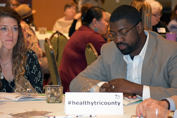 Select Health of South Carolina's Samuel Bellamy listens as Toni Flowers reads statements aloud. Participants put one rock in their bag every time they hears a statement that applied to them.