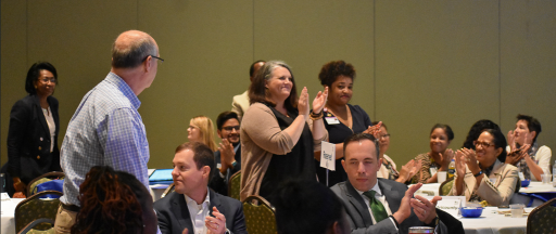 Attendees at Health Symposium stand in applause